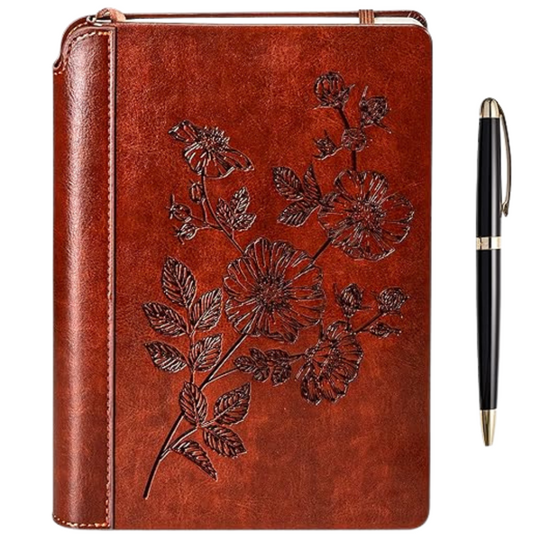 A brown vegan leather journal with a floral embossing design and a luxurious pen placed to its side.