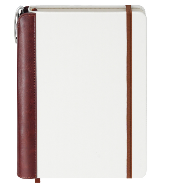 A white and brown vegan leather journal with a pen holder on the side, featuring a luxurious pen attached with a brown ribbon bookmark.