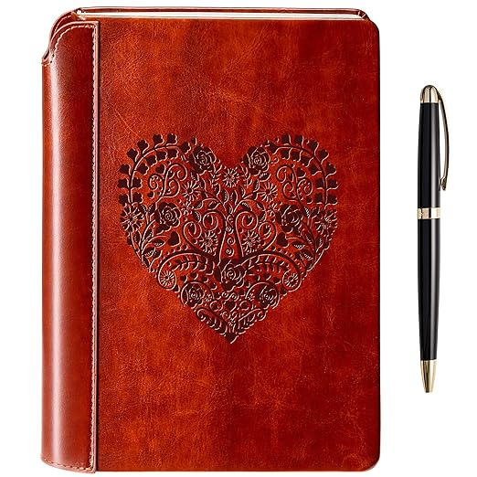 A brown vegan leatherbound journal with a heart design embossed on the cover and a luxurious pen placed to the side.